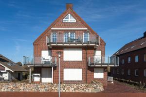 Un edificio de ladrillo rojo con un balcón. en Haus Sanderling Spinnaker16, en Juist
