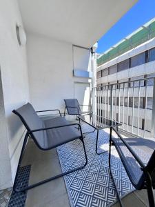 dwa krzesła i stół na balkonie w obiekcie Funky Apartment near Central Station Free Parking w Wiedniu