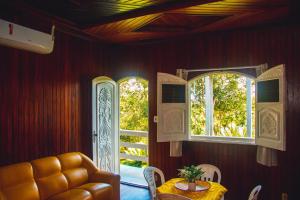 Manacapuru的住宿－AMAZON PARADISE HOTEL，一间带桌子和2个窗户的用餐室