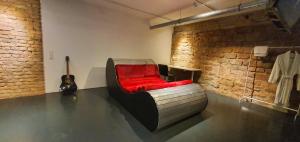 una habitación con una silla roja y una guitarra en Loft im Szeneviertel Mannheims en Mannheim