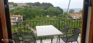 - Balcón con mesa blanca y sillas en Kandilari Apartments, en Kokkino Nero