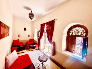 sala de estar con 2 camas y sofá rojo en Riad Prada, en Marrakech