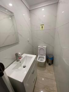 uma casa de banho branca com um lavatório e um WC em just hostel capsules em Alicante