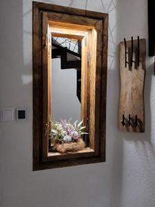 a mirror hanging on a wall with a potted plant at Apartmán v Podkroví in Kremnica