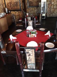 a dining room table with a red table cloth on it at The Big Five Lodge in Gaborone