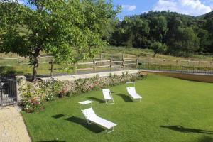 a group of white chairs sitting on the grass at SOCIETA' AGRICOLA LAMBURE SRL in Popiglio