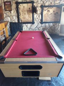 una mesa de billar con una cubierta roja. en The Big Five Lodge, en Gaborone
