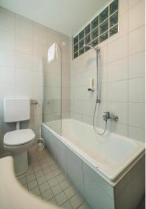 uma casa de banho com um WC, uma banheira e um chuveiro em Hotel Berg em Seekirchen am Wallersee