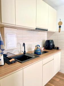 a kitchen with white cabinets and a sink at Apartament Centrum in Łańcut