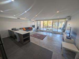 cocina y sala de estar con sofá y mesa en One-bedroom Apartment in heart of the City, en Canberra