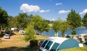 Canet-de-Salars的住宿－Mobilhome 3 étoiles - efb0fi，一组帐篷和一个带湖泊的营地