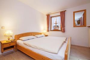 Schlafzimmer mit einem Bett, einem Spiegel und einem Fenster in der Unterkunft Ferienwohnung Oertel in Reit im Winkl