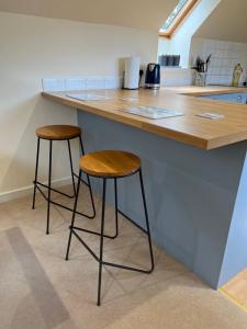 two stools sitting at a counter in a kitchen at Garbity Cottage in Fochabers
