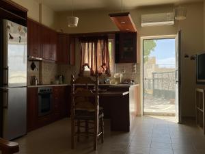 a kitchen with a table and chairs and a window at Spitiko Apartment 1 in Kamilari +6 photos