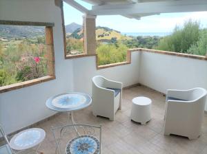 a room with two chairs and a table and two windows at Sardinia Yellow House in Solanas