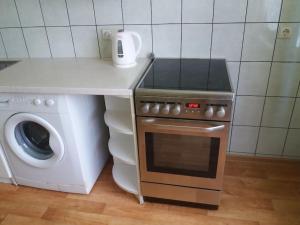 a kitchen with a stove and a washing machine at Apartment in Pašilaičiai. Self check-in. Parking in Vilnius