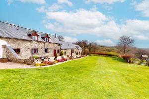 una antigua casa de piedra con un gran patio de césped en Kiri and Norton - joint booking, en Dulverton