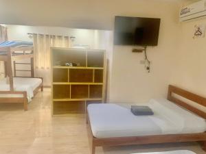 een kamer met 2 bedden en een tv aan de muur bij Adayo Cove Resort in Siquijor