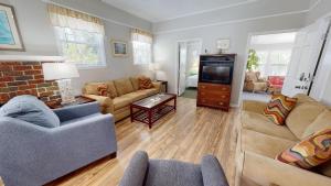 a living room with a couch and a tv at 10 13th Street by Tybee Vacation Rentals in Tybee Island