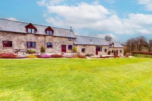 a large stone house with a large yard at Kiri Cottage Hawkridge in Dulverton