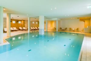 een groot zwembad in een hotellobby bij Hotel Riesberghof in Lindberg