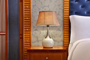 eine Lampe auf einem Nachttisch neben einem Bett in der Unterkunft The Ritz-Carlton Jeddah in Dschidda