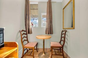 a table and two chairs in a room with a mirror at Park Motel in Toronto