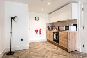 uma cozinha com armários brancos e piso em madeira em Lovely 1 Bedroom Apartment in Central Sheffield em Sheffield