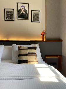 a bed with a pillow and three pictures on the wall at GalataCo Hotel in Istanbul