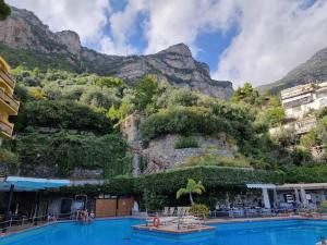 een groot zwembad met een berg op de achtergrond bij Apartment Hotel Royal con balcone e vista mare in Positano