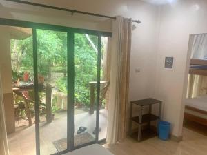 een kamer met een glazen schuifdeur naar een patio bij Adayo Cove Resort in Siquijor