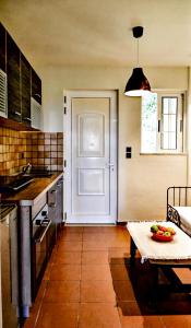 a kitchen with a table and a white door at Kamara Apartments Marmari in Marmari