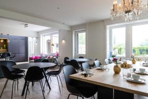 ein Restaurant mit Tischen und Stühlen und einem Kronleuchter in der Unterkunft Tuss in Kortrijk