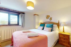 a bedroom with a large bed and a window at Norton Cottage Hawkridge in Dulverton