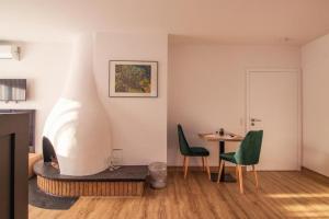 sala de estar con mesa y 2 sillas verdes en Hotel Dona, en Bergisch Gladbach