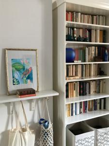 une chambre avec des étagères blanches remplies de livres dans l'établissement Casa di Luca, à Viareggio