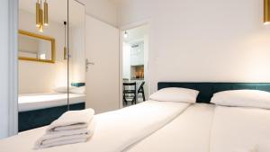 a bedroom with a white bed and a mirror at City Center SPA Apartments Pool & Parking in Gdańsk