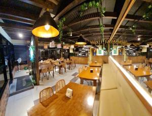 een restaurant met houten tafels en stoelen en een cafetaria bij Antonio's Inn in Calbayog