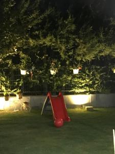 a red slide in a yard at night at Villa 19 Apart Otel in Ilıca