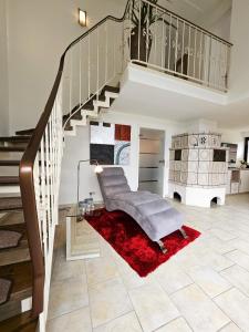 een woonkamer met een trap en een rood tapijt bij Design Apartment Grünwald große Wohnung auf 2 Etagen in Hahnenklee-Bockswiese