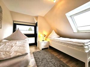 een slaapkamer met twee bedden en een raam bij Design Apartment Grünwald große Wohnung auf 2 Etagen in Hahnenklee-Bockswiese