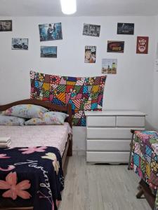 a bedroom with a bed and a dresser and pictures on the wall at Hostel & Pousada UFPE INN in Recife