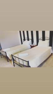grupa trzech łóżek w pokoju w obiekcie Villa Maria 1 w mieście Liapades