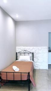 łóżko w pokoju z białą ścianą w obiekcie Villa Maria 1 w mieście Liapades