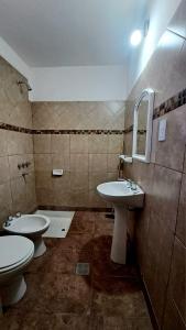 een badkamer met 2 wastafels, een toilet en een spiegel bij Hosteria Tumbaya in Tumbaya