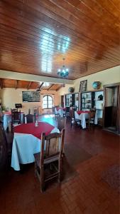 een eetkamer met tafels en stoelen en houten plafonds bij Hosteria Tumbaya in Tumbaya