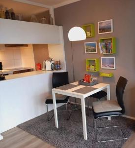a kitchen with a table and two chairs in a room at Ferienwohnung mit Weitblick & Strandlage in Sierksdorf
