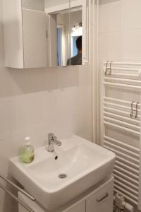 a white bathroom with a sink and a mirror at Ferienwohnung mit Weitblick & Strandlage in Sierksdorf +33 photos