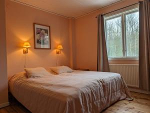a bedroom with a large bed and a window at Brukshotellet Öland - Vandrarhem in Degerhamn