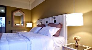 um quarto com uma grande cama branca e um espelho em Kamara Apartments Marmari em Marmari